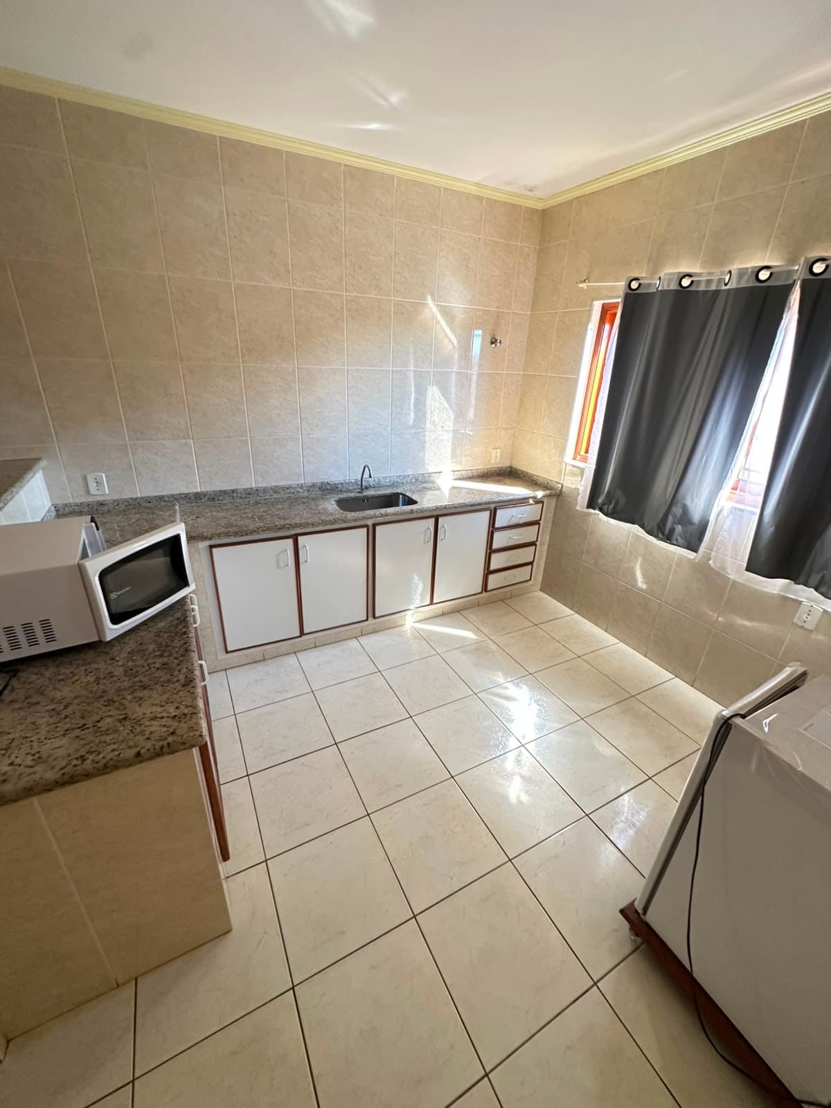 Cozinha da Pousada Cabana com fogão, micro-ondas e frigobar