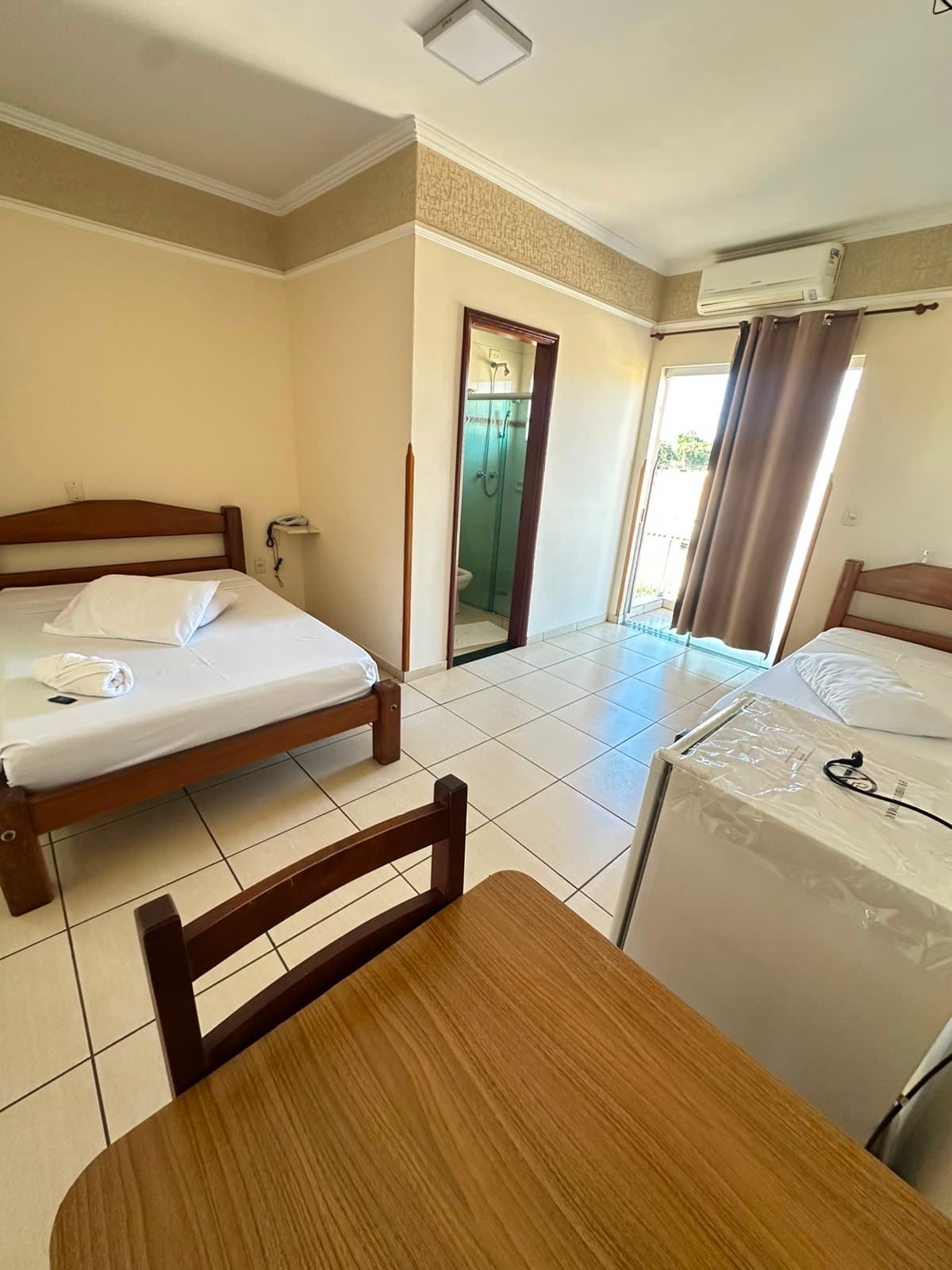 Quarto da Pousada Cabana com duas camas, frigobar e varanda